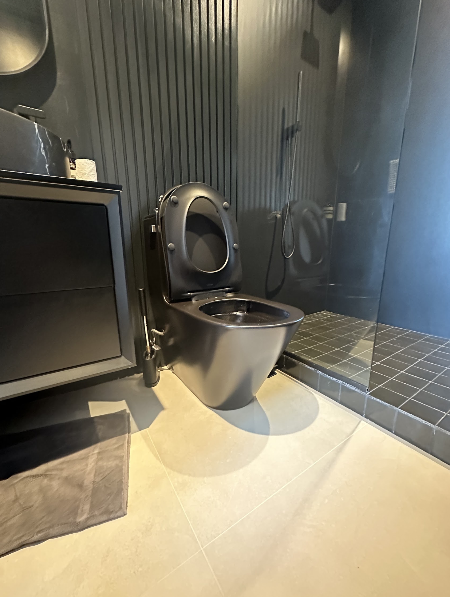 Stainless steel commercial toilet with commercial flush valve installed on industrial flooring in an Astoria food service commercial space
