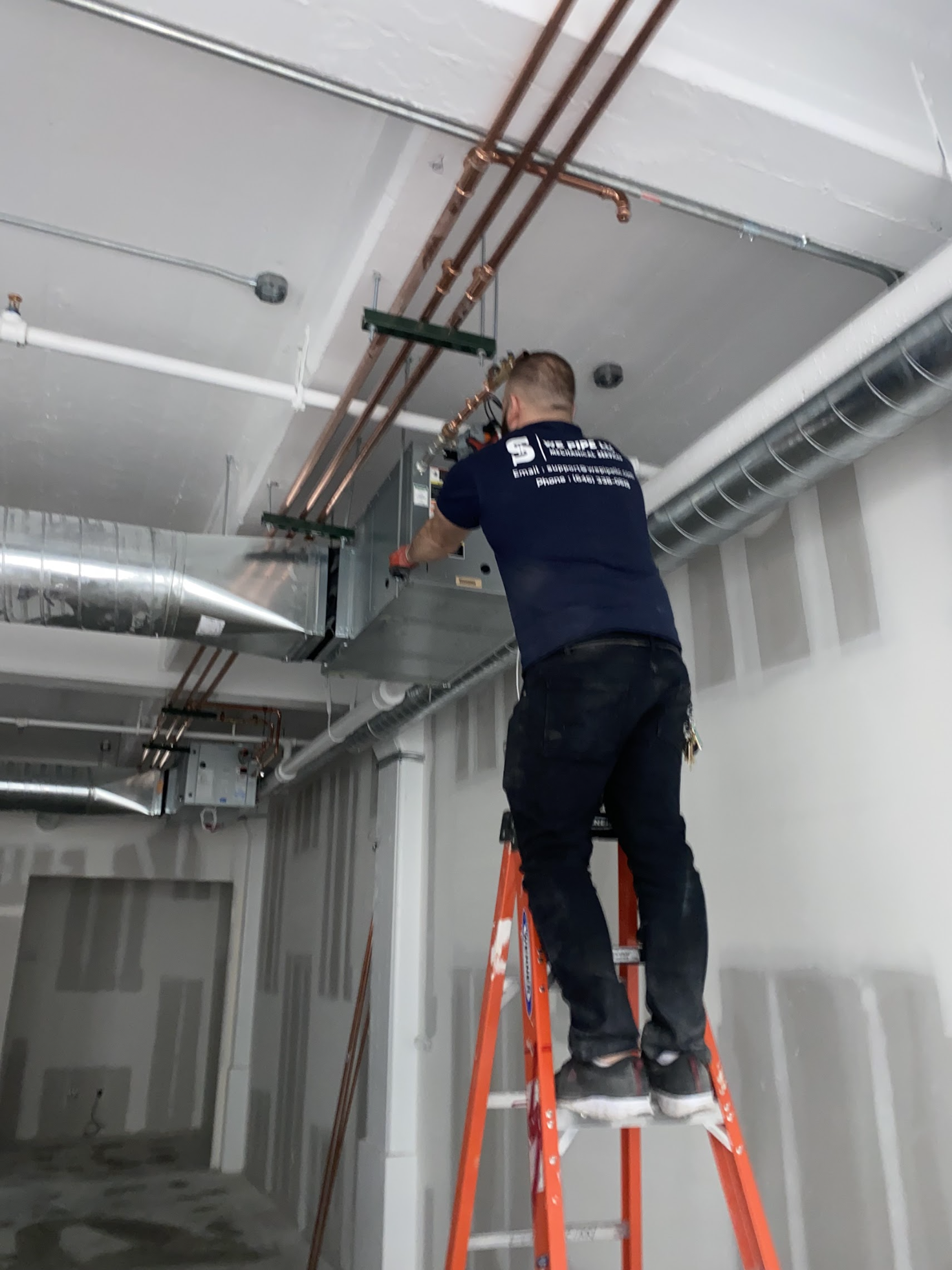 We Pipe LLC technician installing copper pipe runs along the ceiling in East Williamsburg, Brooklyn