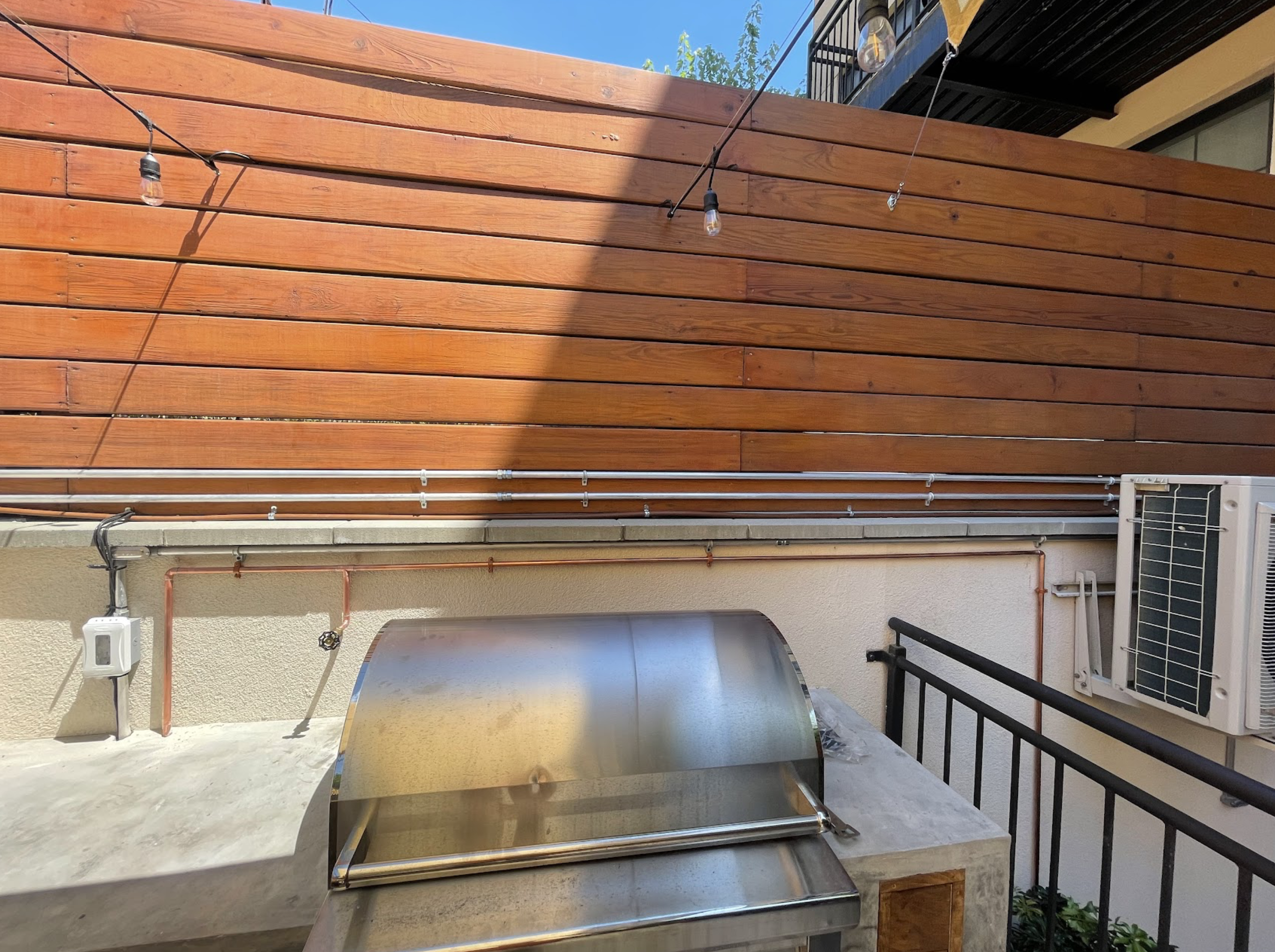 Vertical indirect water heater tank with stainless supply and return lines, insulation wrapping, and professional installation in a Glendale pre-war home mechanical room