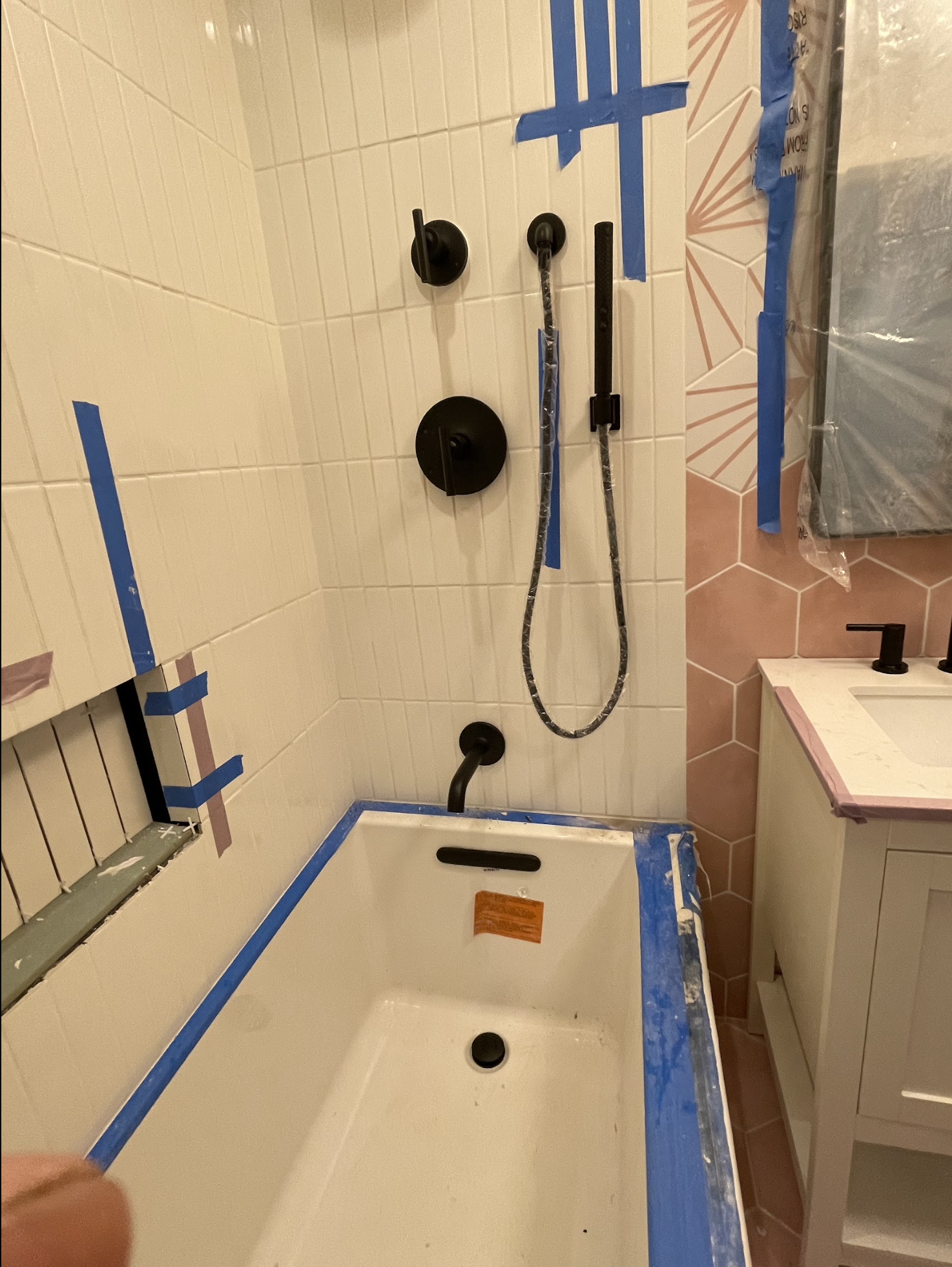 Multi-head shower system installation in progress in a Maspeth brick row house, multiple shower outlets roughed in with white subway tile walls