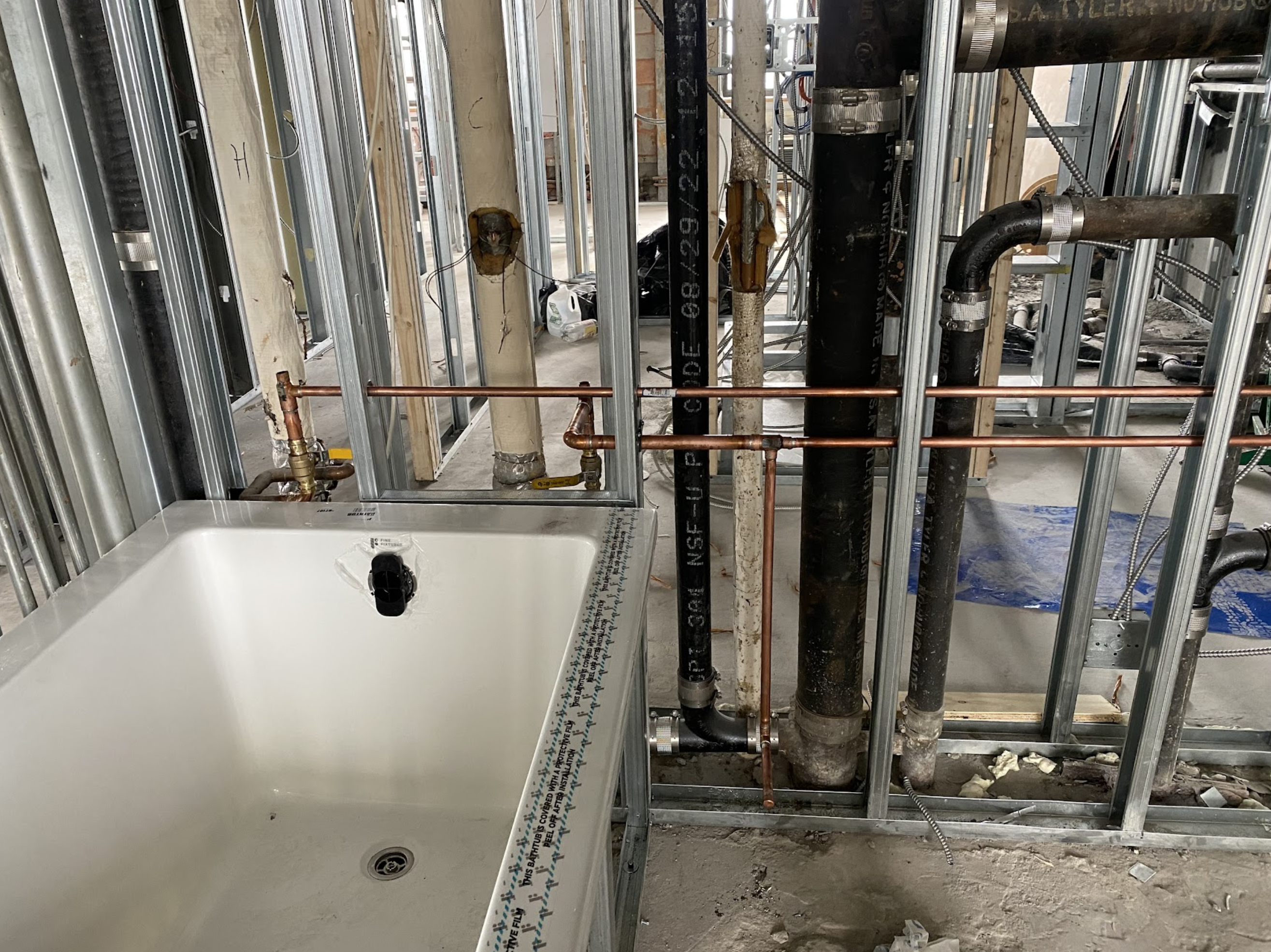 Completed bathroom renovation with white double-sink vanity, chrome faucets, recessed lighting, and gray tile walls in a Sunnyside co-op apartment