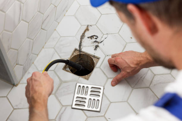 Plumber snaking a floor drain, drain cleaning and sewer service in Brooklyn and Queens