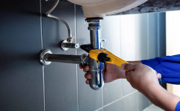 Plumber tightening under-sink drain pipe with a wrench, plumbing repair in Brooklyn and Queens